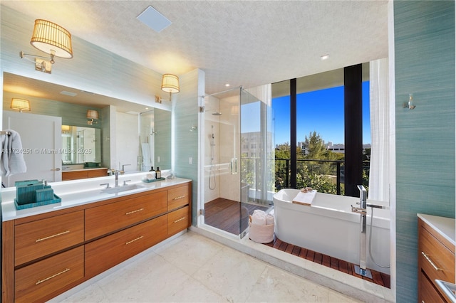 bathroom with independent shower and bath, vanity, and a textured ceiling