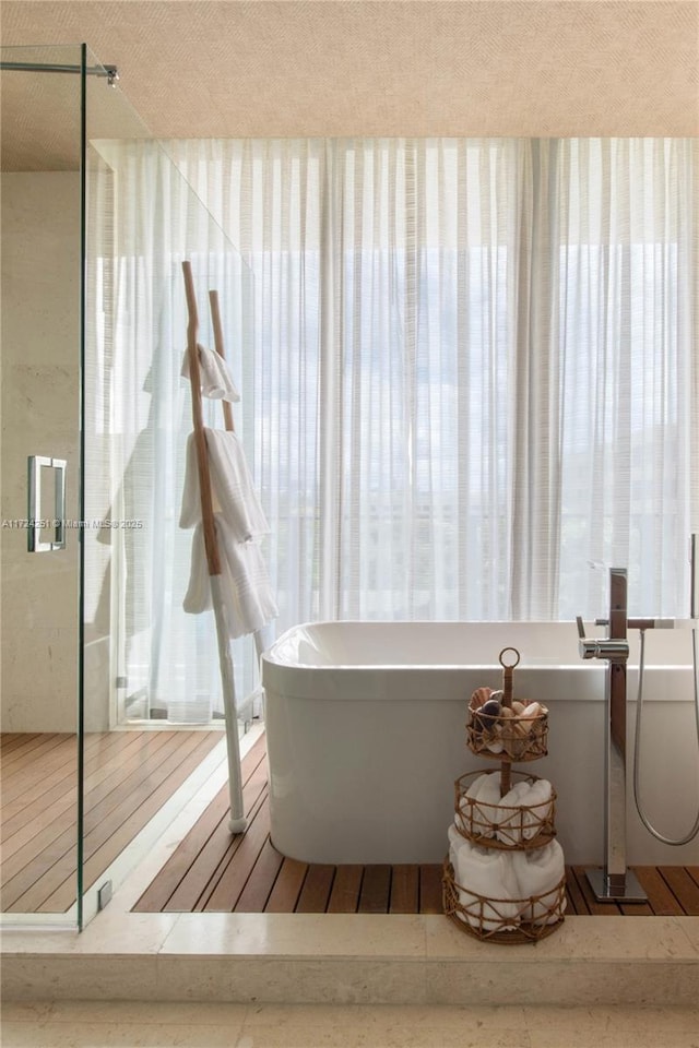 bathroom featuring hardwood / wood-style flooring and a tub to relax in