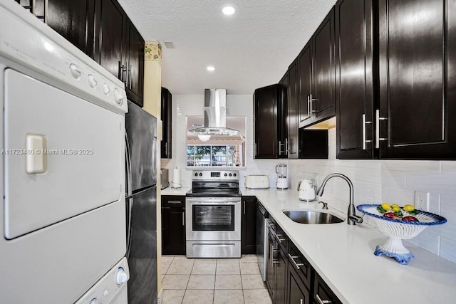 kitchen featuring sink, stacked washing maching and dryer, refrigerator, electric range, and exhaust hood