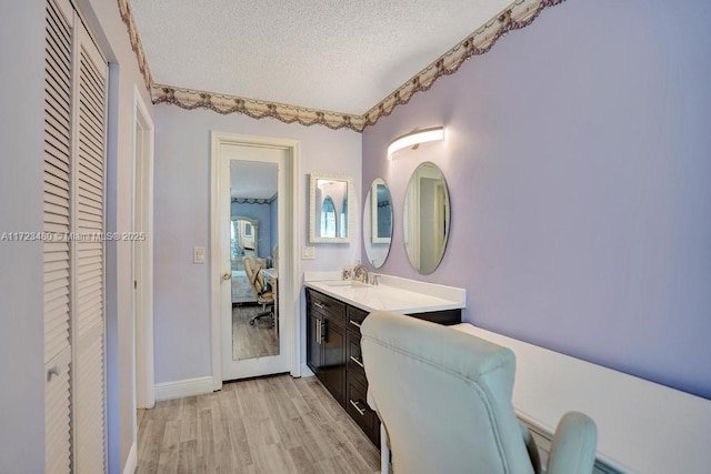 bathroom with vanity, a textured ceiling, and hardwood / wood-style floors