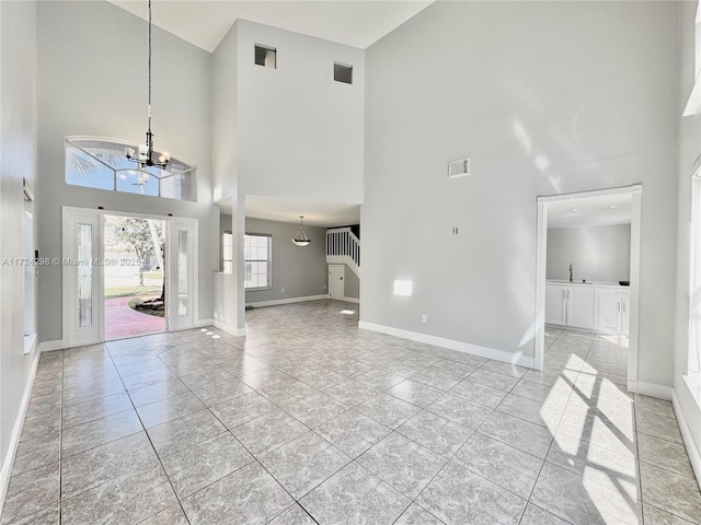 tiled entrance foyer featuring a high ceiling and an inviting chandelier