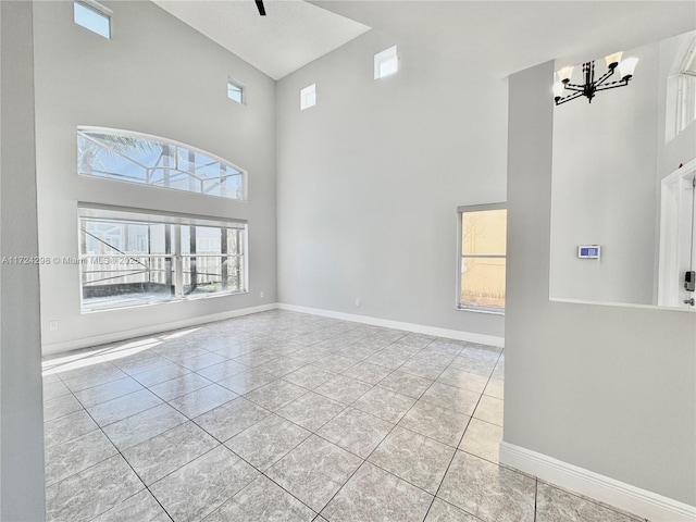 interior space with light tile patterned floors, a high ceiling, and a chandelier