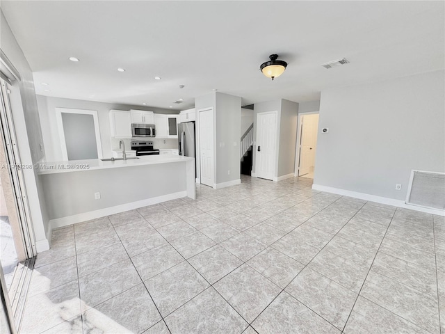 unfurnished living room featuring sink and light tile patterned floors