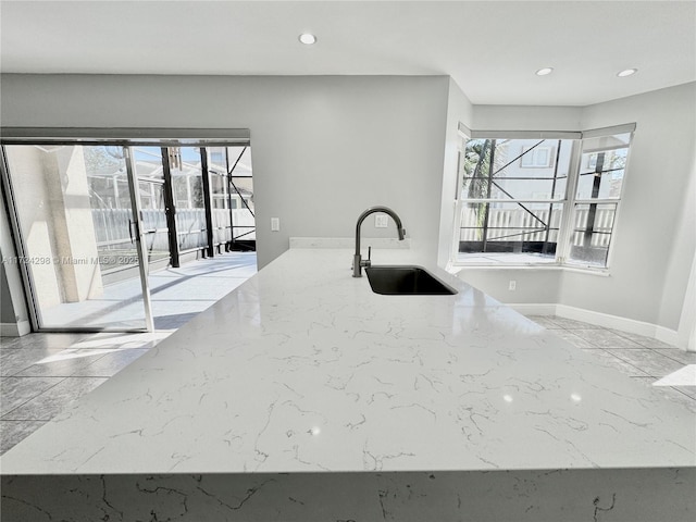 kitchen with light stone countertops and sink