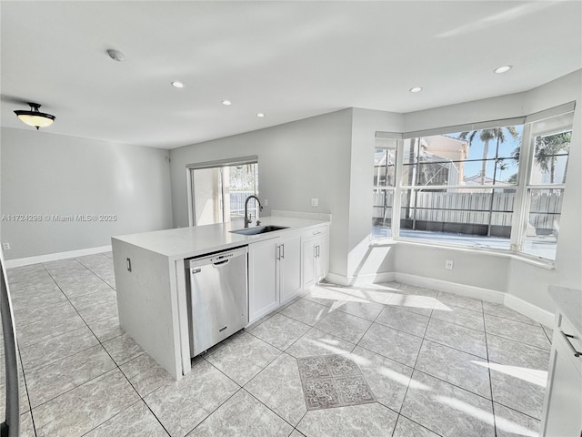 kitchen with sink, light tile patterned floors, stainless steel dishwasher, kitchen peninsula, and white cabinets