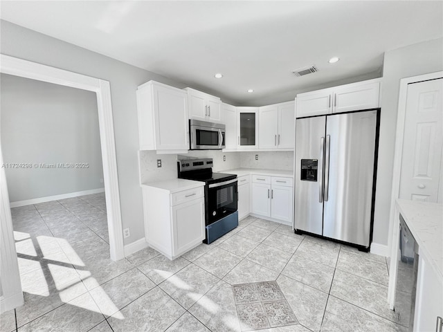 kitchen with white cabinets, stainless steel appliances, and light tile patterned floors