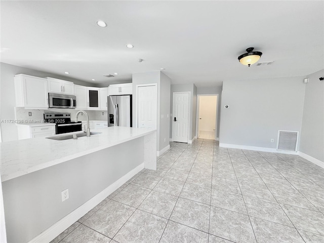 kitchen featuring white cabinetry, light stone countertops, sink, and stainless steel appliances