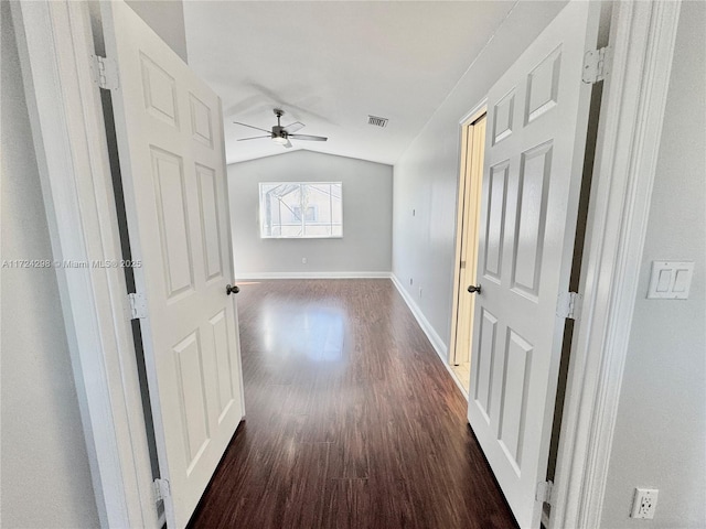 hall featuring dark wood-type flooring and vaulted ceiling