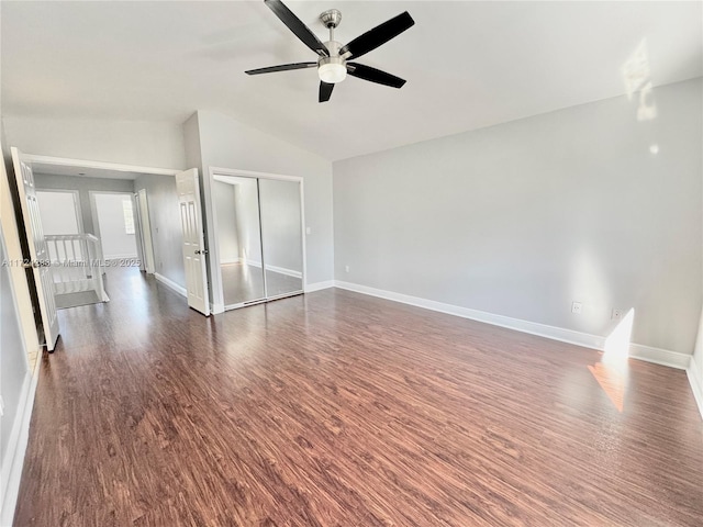 empty room with ceiling fan, dark hardwood / wood-style floors, and vaulted ceiling