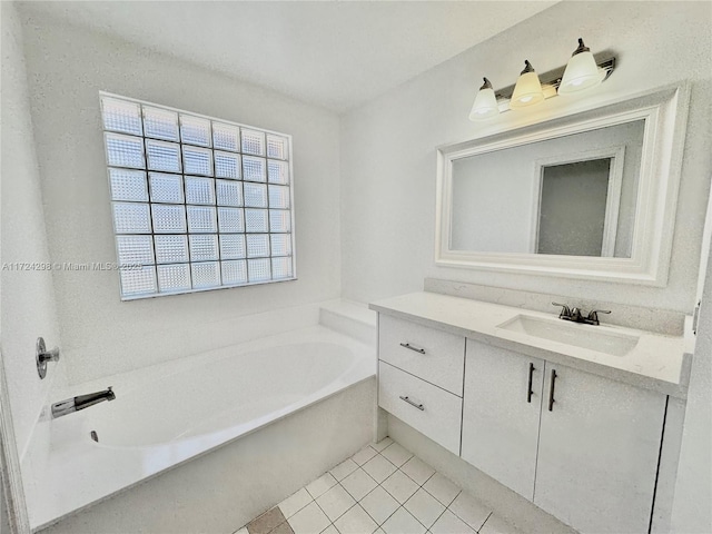 bathroom with tile patterned floors, a tub, and vanity