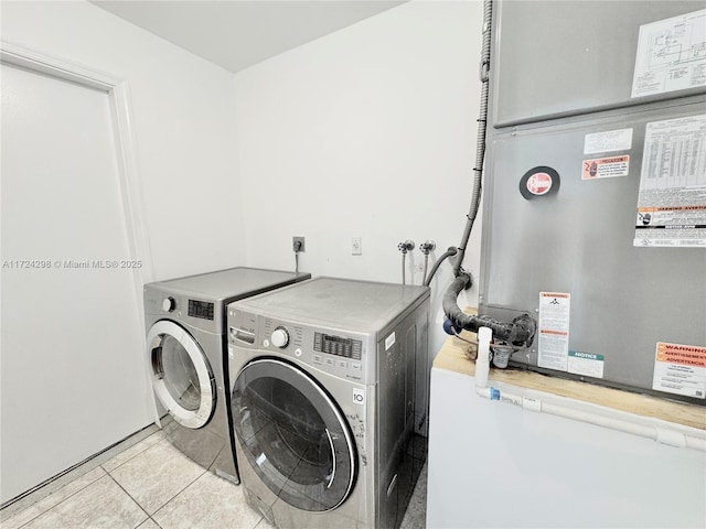 washroom with light tile patterned flooring, washing machine and dryer, and heating unit