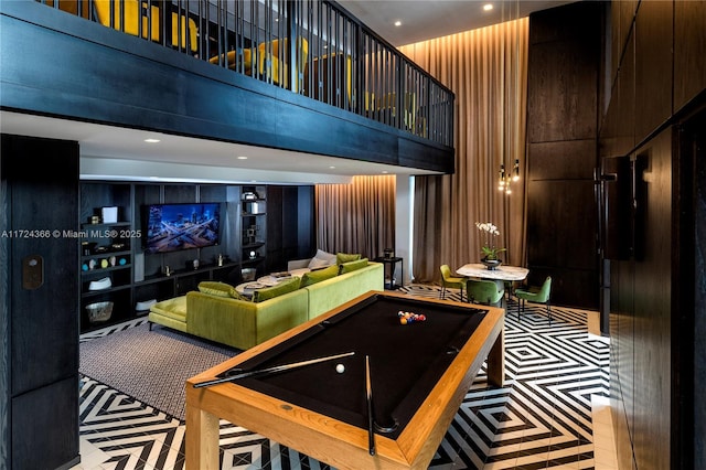 playroom with a high ceiling, light colored carpet, wooden walls, and pool table