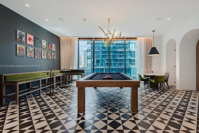 playroom with a notable chandelier, floor to ceiling windows, and billiards