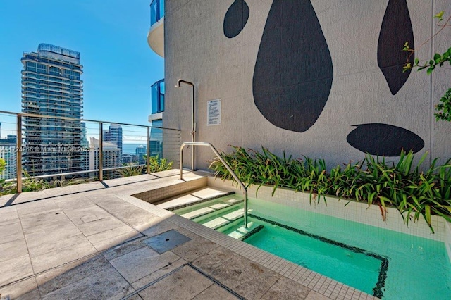 view of swimming pool with an in ground hot tub