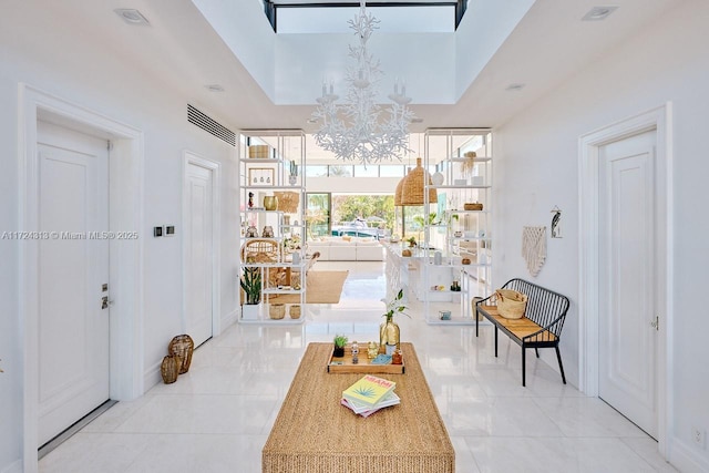 interior space featuring a towering ceiling and a chandelier