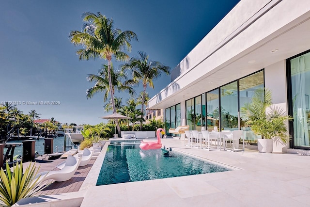 view of swimming pool featuring a water view and a patio