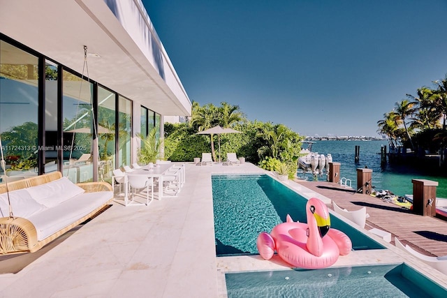 view of swimming pool featuring a water view and a patio