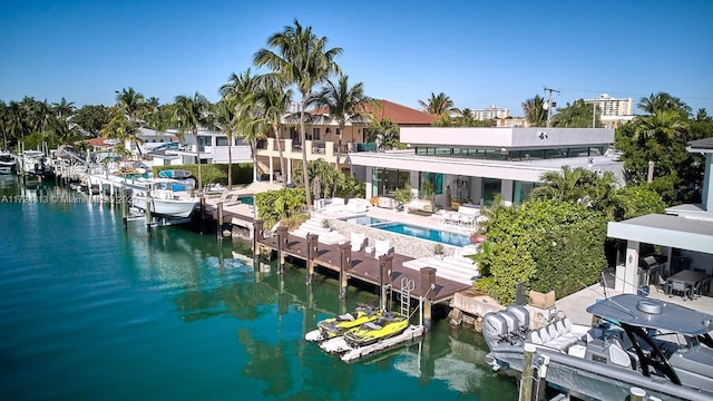 exterior space with a water view, a patio area, and a pool with hot tub