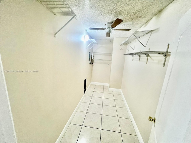 walk in closet with ceiling fan and light tile patterned flooring