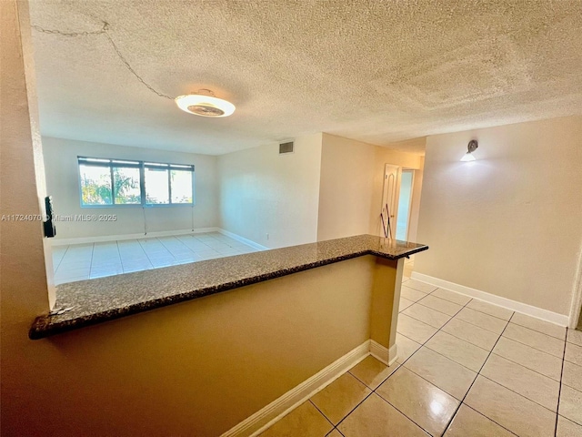 tiled spare room with a textured ceiling