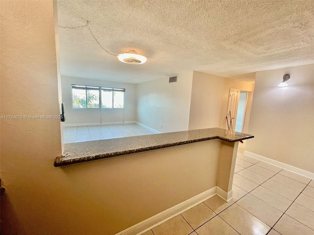 spare room with light tile patterned floors and a textured ceiling