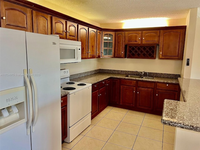 kitchen with a textured ceiling, white appliances, light tile patterned floors, and sink