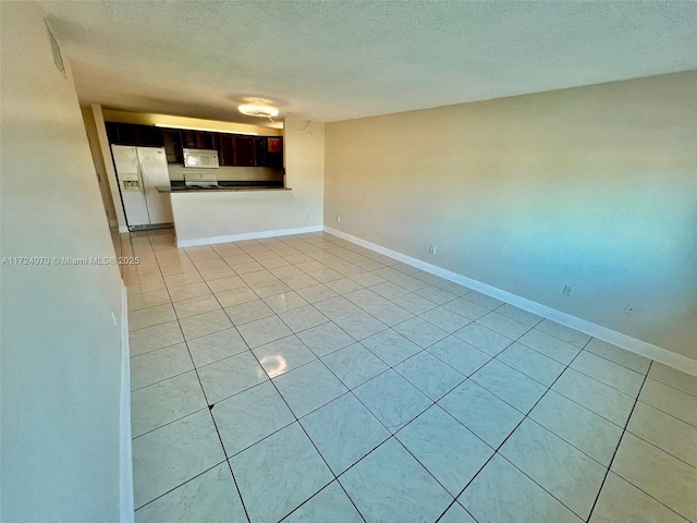 unfurnished living room with light tile patterned flooring and a textured ceiling