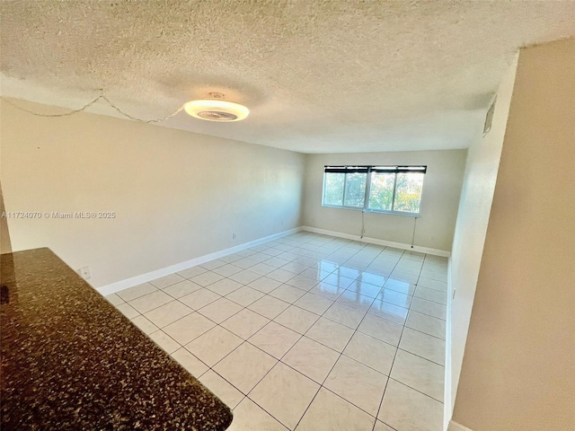 tiled spare room featuring a textured ceiling