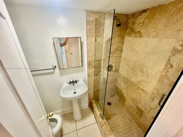 bathroom featuring a textured ceiling, tiled shower, and tile patterned floors