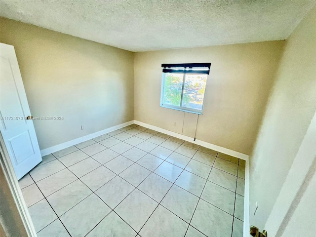 unfurnished room with light tile patterned floors and a textured ceiling