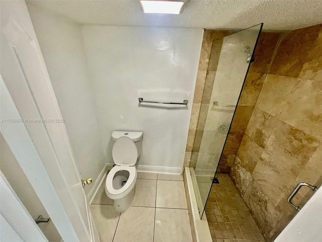 bathroom featuring a tile shower, a textured ceiling, toilet, and tile patterned floors