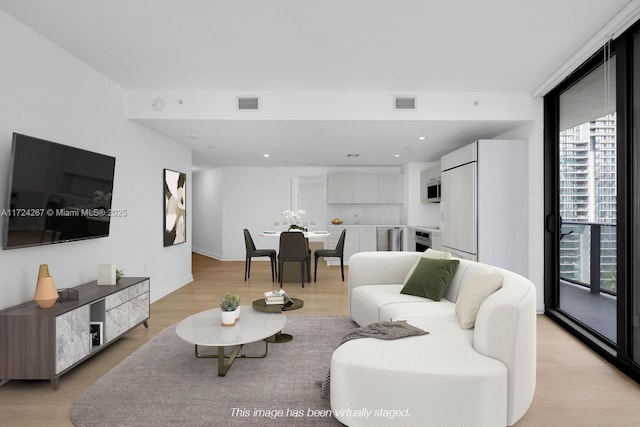 living room with floor to ceiling windows and light wood-type flooring