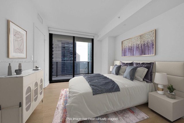 bedroom with access to outside, floor to ceiling windows, and light wood-type flooring