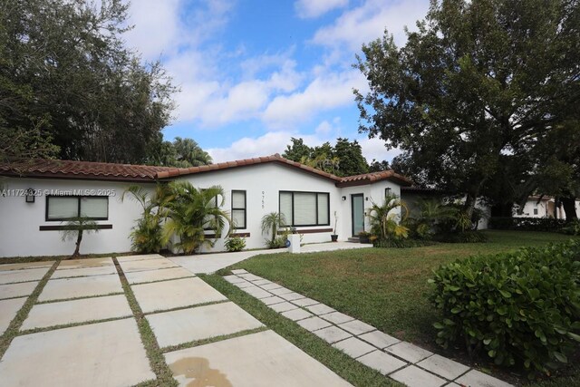 mediterranean / spanish house with a front lawn