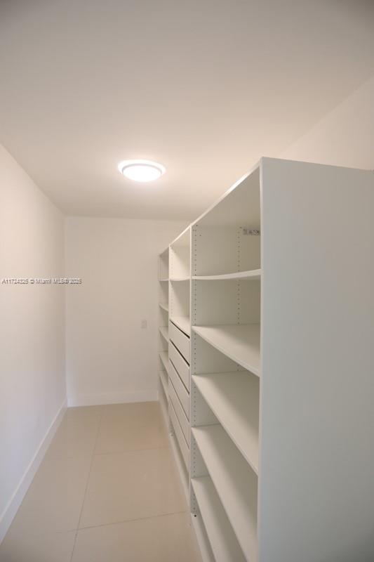 walk in closet featuring light tile patterned flooring