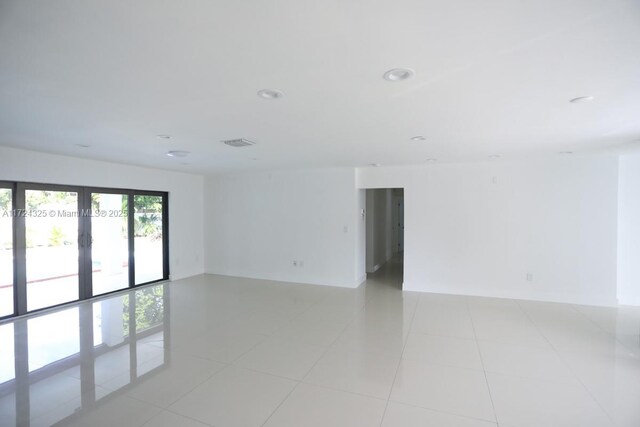 unfurnished room with french doors and light tile patterned flooring