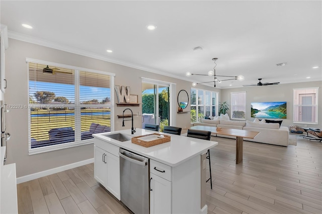 kitchen with dishwasher, a breakfast bar, a center island with sink, white cabinets, and sink