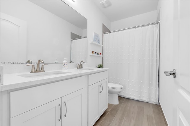 bathroom with hardwood / wood-style floors, vanity, and toilet