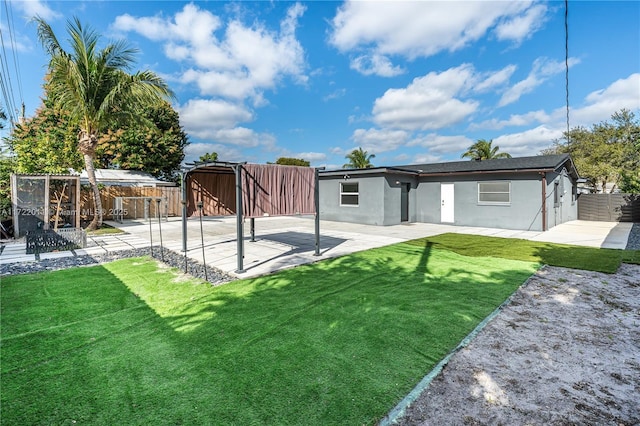 back of house featuring a patio area and a yard