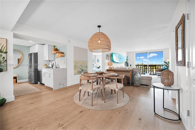 dining area featuring sink and light hardwood / wood-style floors