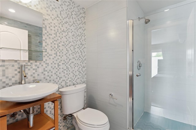 bathroom featuring an enclosed shower, tile walls, and toilet