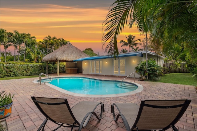 pool at dusk with a gazebo and a patio