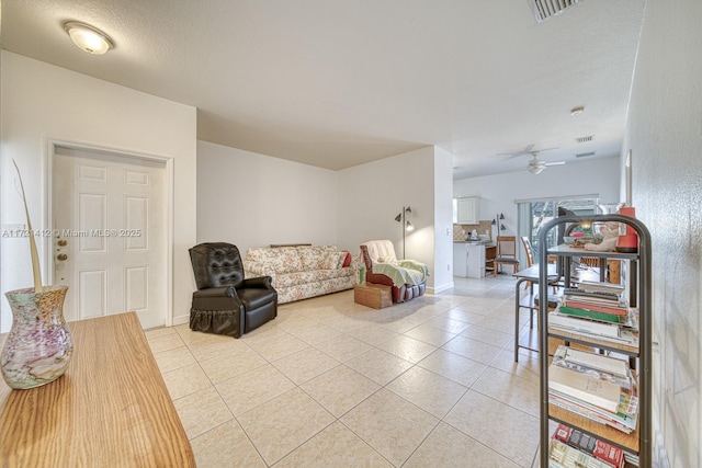 living room featuring ceiling fan, light tile patterned floors, and a textured ceiling