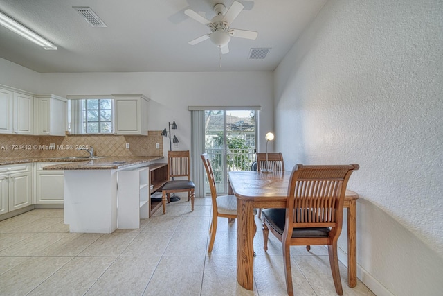 tiled dining space featuring ceiling fan and sink