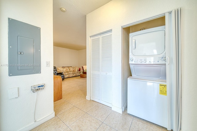 washroom featuring electric panel, stacked washer and dryer, and light tile patterned floors