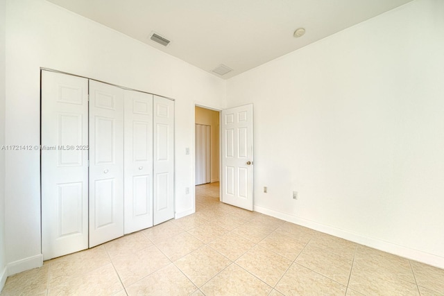 unfurnished bedroom with light tile patterned floors and a closet