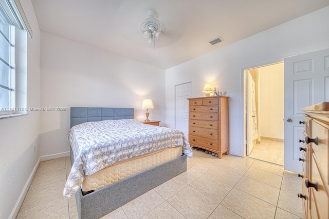 bedroom with ceiling fan, light tile patterned flooring, and ensuite bathroom