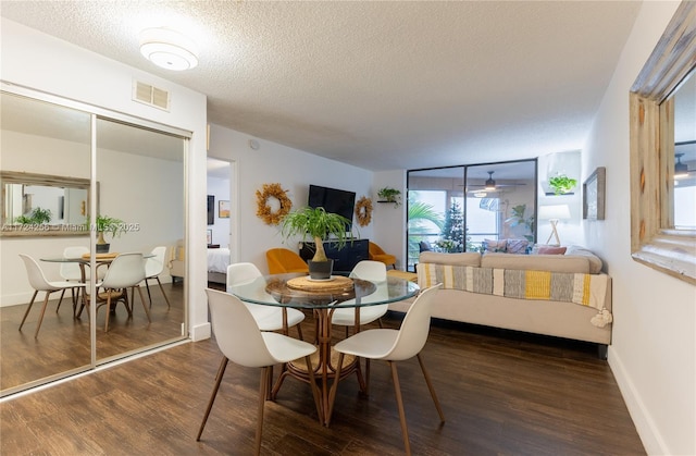 dining space with ceiling fan, floor to ceiling windows, dark hardwood / wood-style flooring, and a textured ceiling