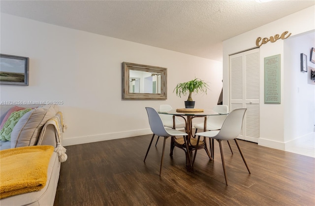 dining room featuring a textured ceiling and dark hardwood / wood-style flooring