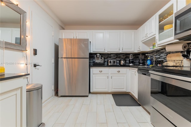 kitchen with backsplash, white cabinetry, and appliances with stainless steel finishes